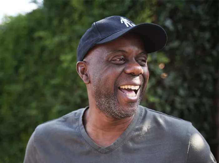 Black man wearing a baseball cap looking to his left