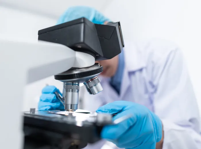 Scientist looking into microscope for prostate cancer research