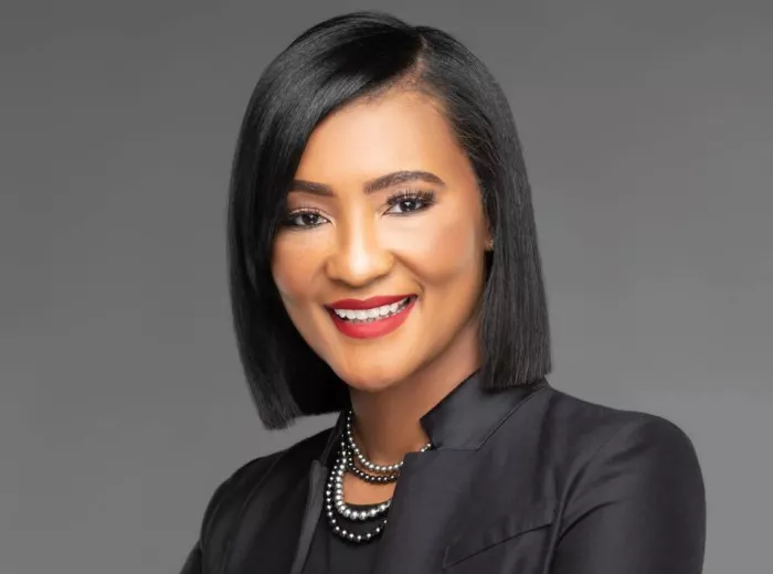 African American woman with a slick haircut and wearing black suit