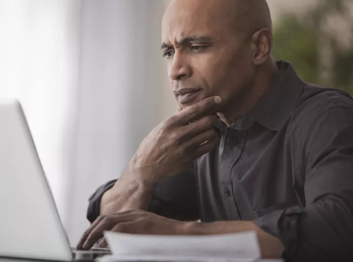 Middle aged black man looking at laptop