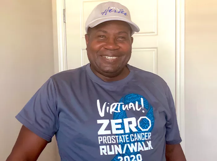 Black man in a white ZERO Champions hat and a Virtual Run/Walk shirt