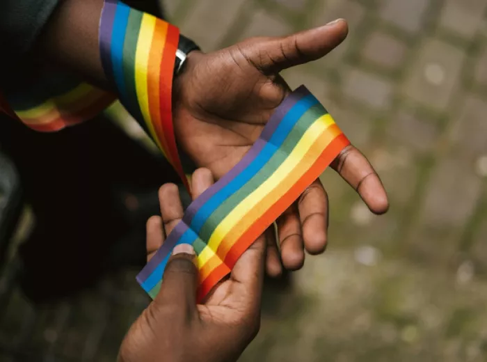 Hand holding a rainbow string