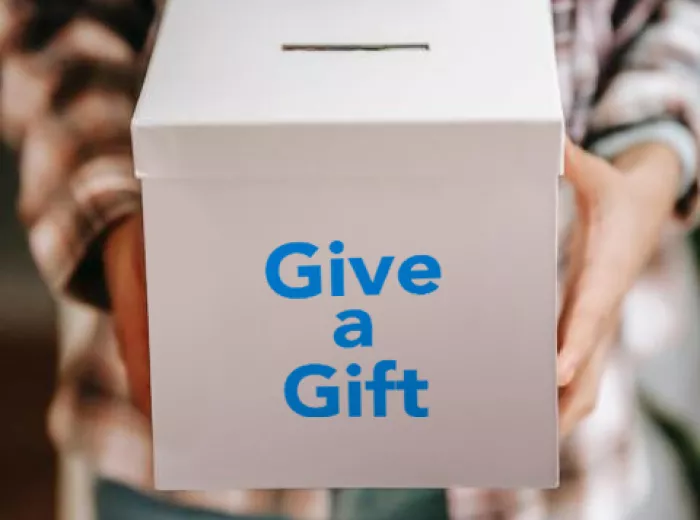 Man holding box that says 'Give a Gift'