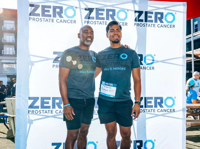 Two men standing in front of a ZERO backdrop at a Run/Walk event