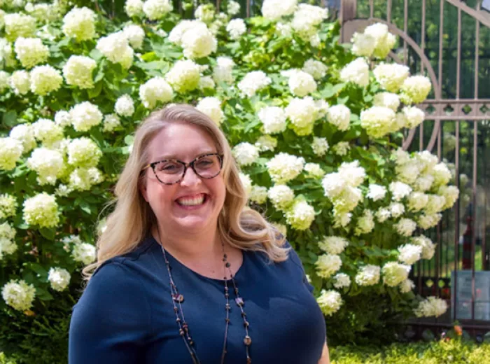 Headshot of Amanda Hasse in front of white flowers