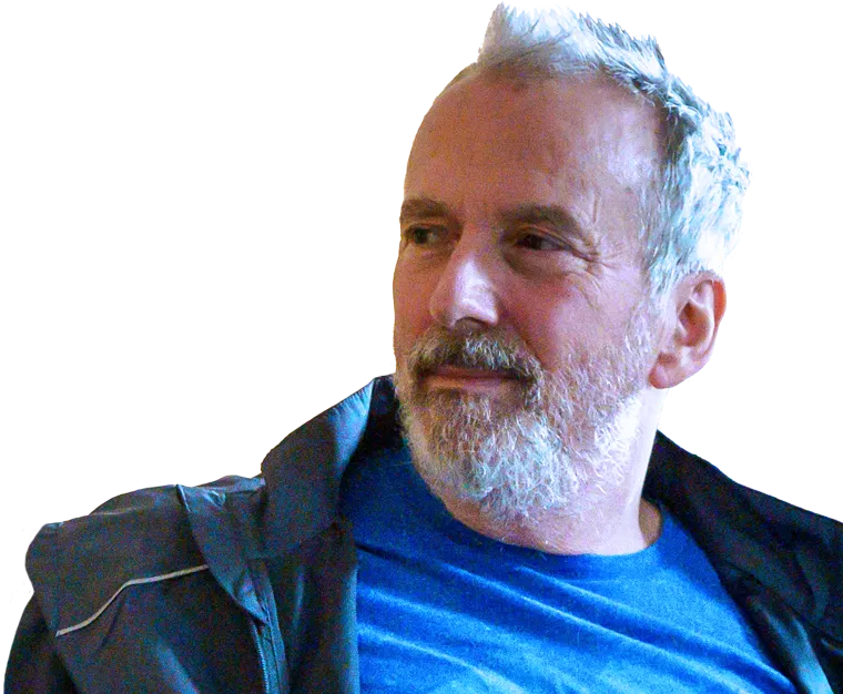 White middle-aged man, Ted Healy, in a blue t-shirt sitting on a sofa