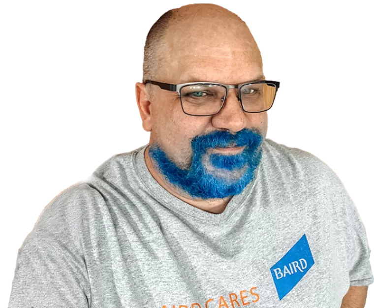 A white man with a blue beard wearing glasses and a shirt that says "Baird Cares"