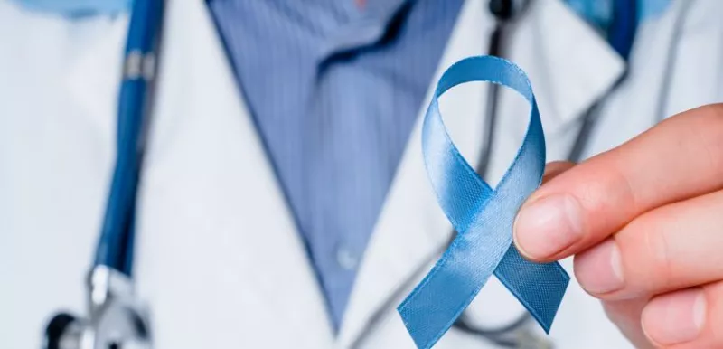 Doctor holding up a blue ribbon for prostate cancer awareness