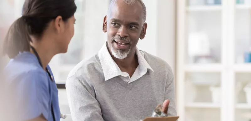Black male talking to his nurse about health disparities 