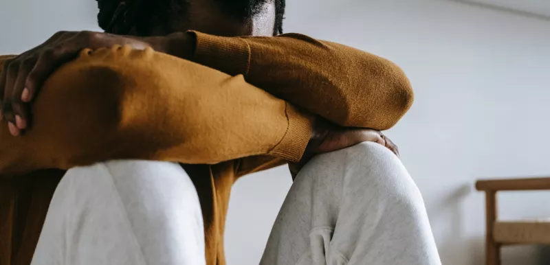Man sitting resting head and arms on knees
