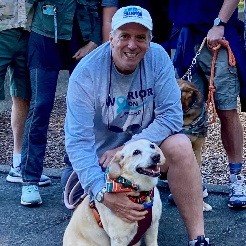 Man in a ZeroProstateCancer shirt with his dog at a charity run walk event