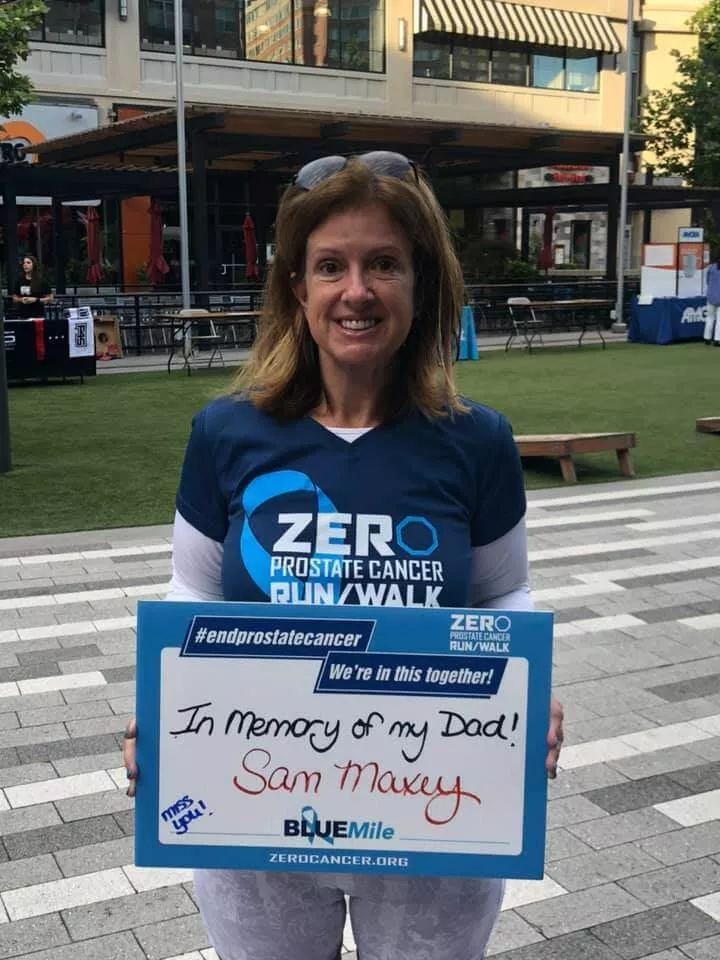 Sandy Maxey holding up a memory sign for Sam Maxey at a ZERO Prostate Cancer run/walk event