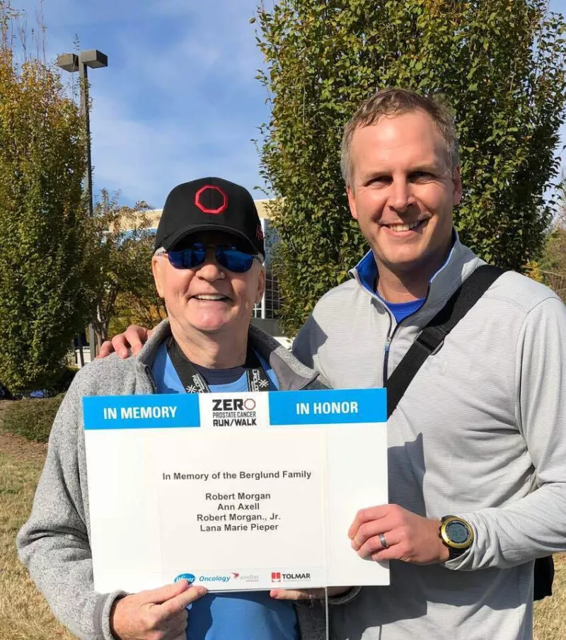 Barry and son Morgan hold up a sign in memory of the Berglund family