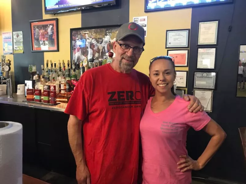 Two friends standing together in a sports bar