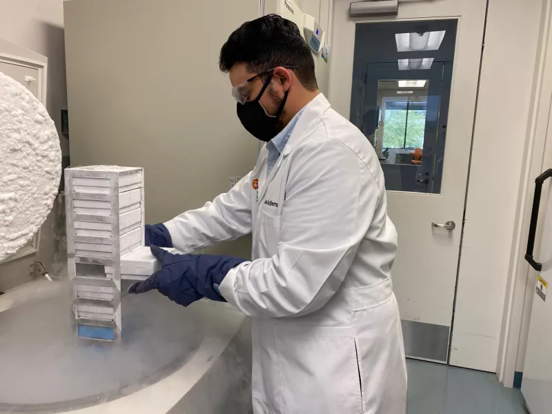 Jose Gutierrez in lab coat and gear working on a research project