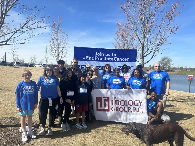 A group of people hold up a sign at the Memphis Run/Walk while a dog enters the frame 