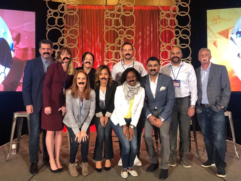 Business professionals wearing goofy fake moustaches