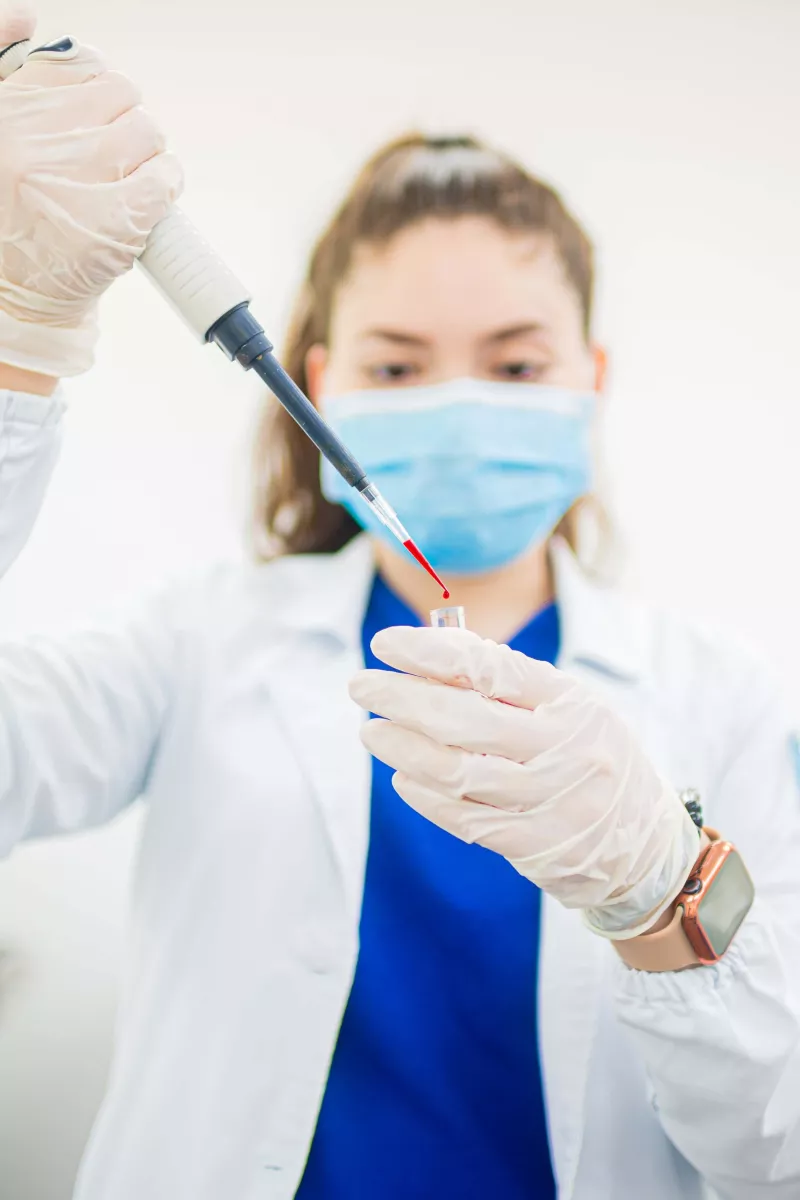 Woman in a Lab Coat Holding a Test Tube