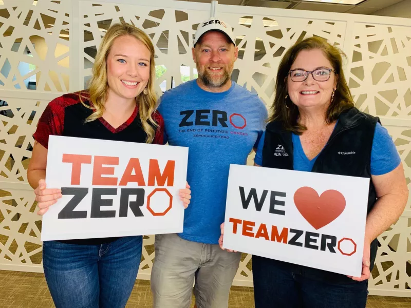 Jamie Bearse and team holding up We Love Team ZERO signs