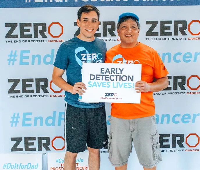 Two men holding a sign that says "Early Detection Saves Lives"