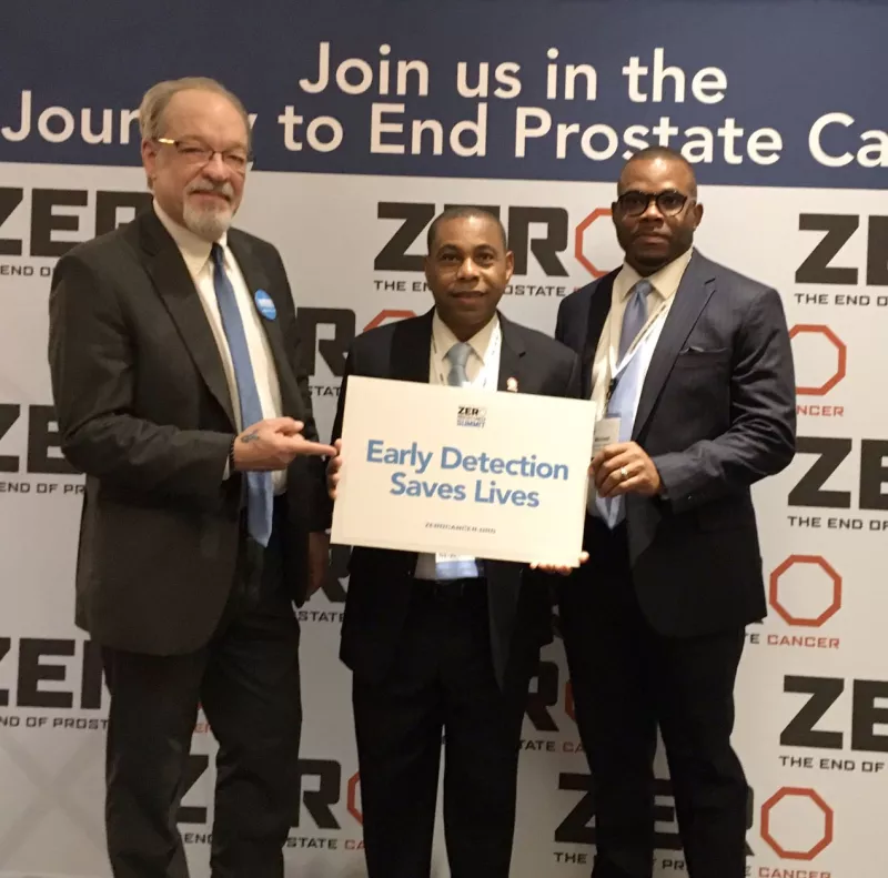 Mike and others hold a sign that says 'Early Detection Saves Lives'