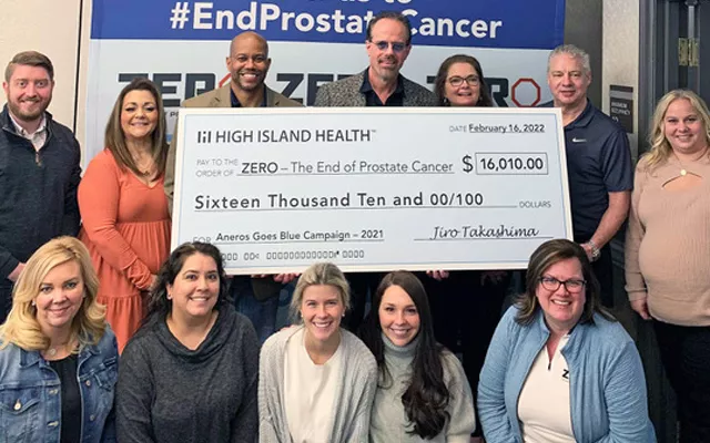 A group of people holding a large donation check