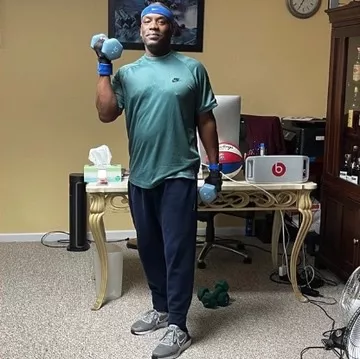 African American man in sports gear lifting weights