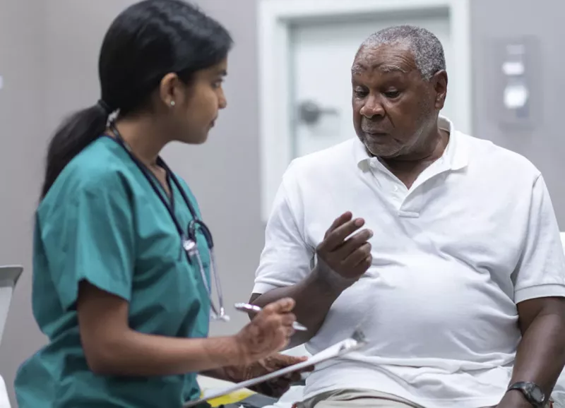 An African American man talking to a female doctor