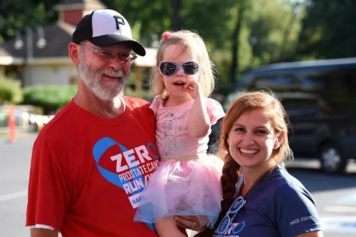 Elderly man holding his granddaughter and his daughter
