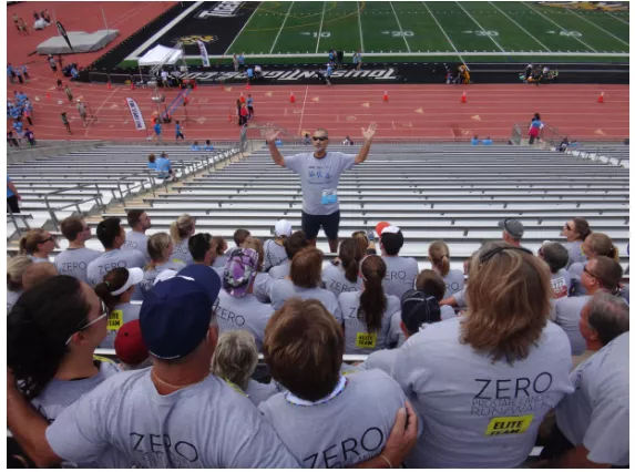 A man talking to a group of people at a baseball stadium