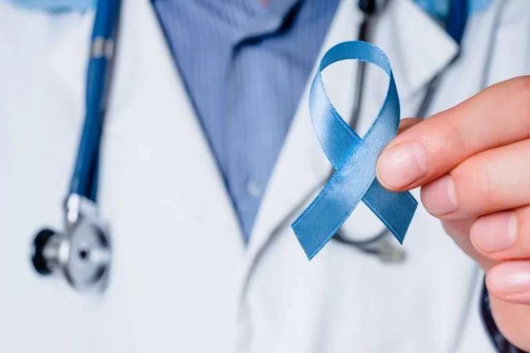 Medical doctor holding a blue ribbon