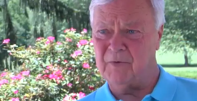 Middle-aged man with grey hair wearing a blue polo shirt