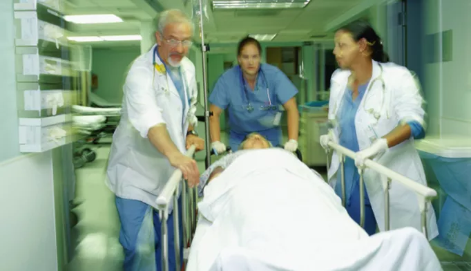 Three doctors pushing a gurney with a patient