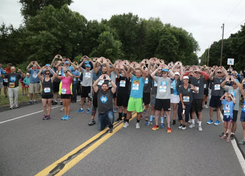 Run Walk Event holding up hands forming hearts