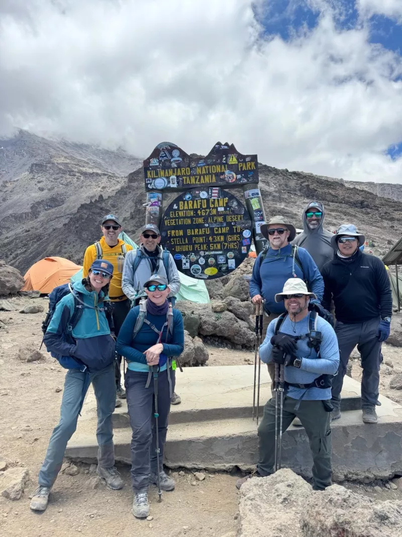 hikers at a sign on Kilimanjaro