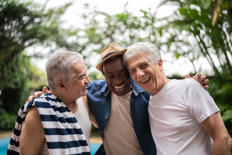 three men smiling outside