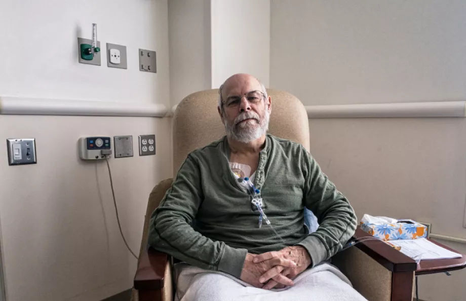 A man sitting in a chair in the hospital receiving chemotherapy treatment