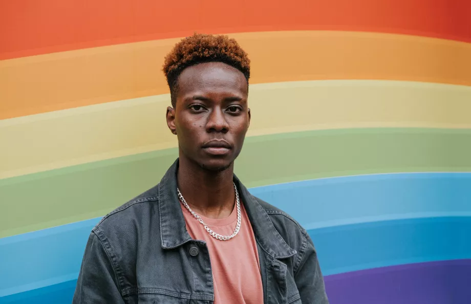 Young African American man in front of the rainbow flag