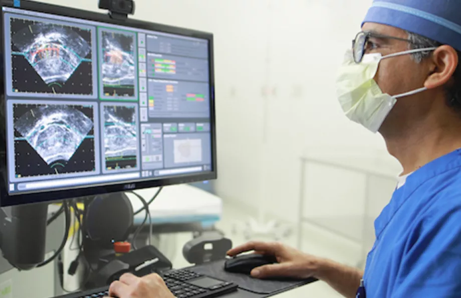 Doctor standing at computer looking at ultrasound images
