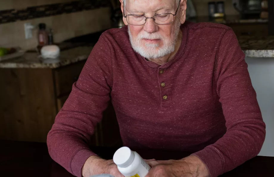Elderly man looking at bottles with pills