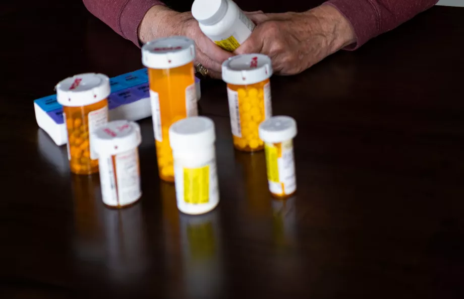 Elderly man looking at bottles with pills