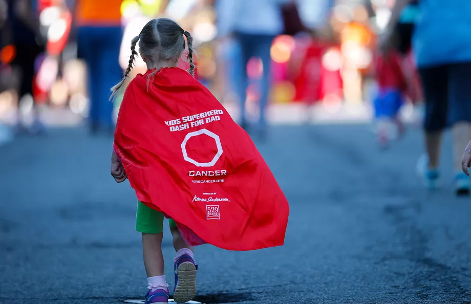 Young girl wearing a superhero cape