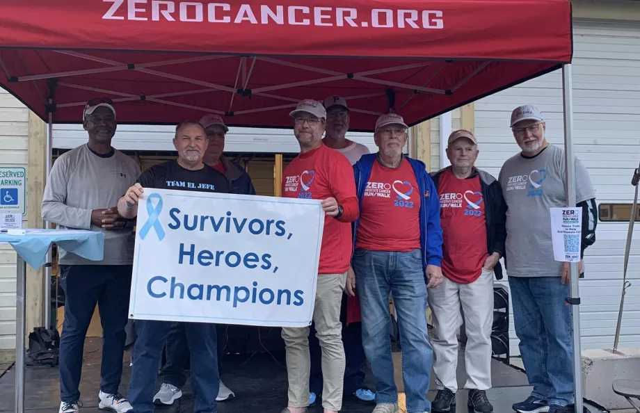 Group of men holding a Survivors & Heroes sign