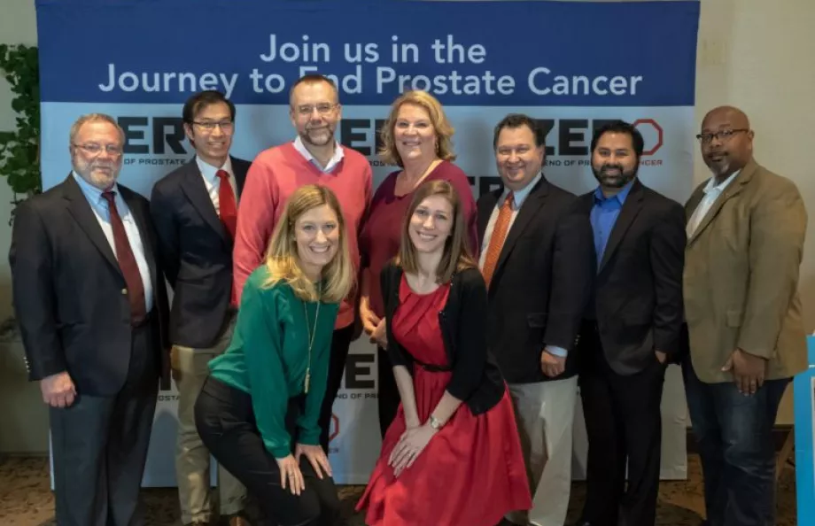 Group of people posing in front of a banner
