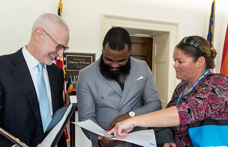 Three advocates looking at papers inside of folders at the Capitol 