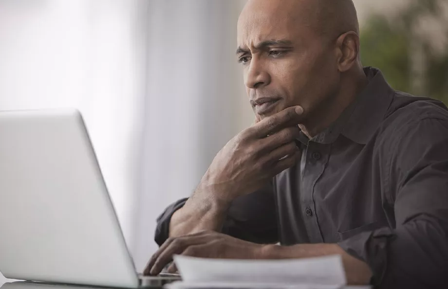 Middle aged black man looking at laptop