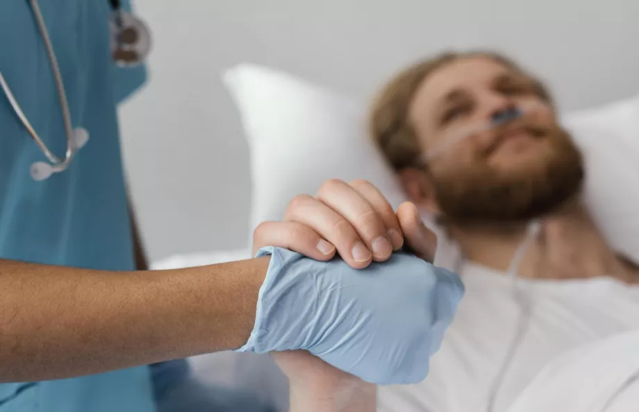 Close up photo of a patient and health worker holding hands
