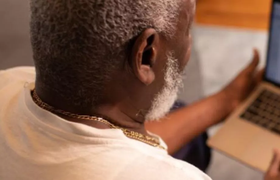 Man Looking at his laptop while sitting and reading about prostate news