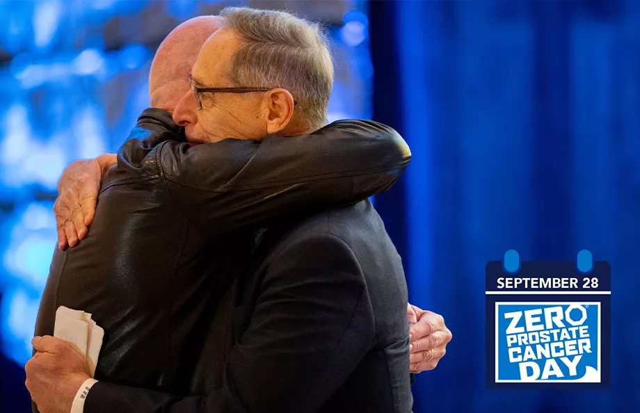 ZERO Chairman, Tom Bognanno, embracing someone for a hug at the 2023 Bold for Blue Awards. The ZERO Prostate Cancer Day logo and date (September 28) is in the bottom right corner. 