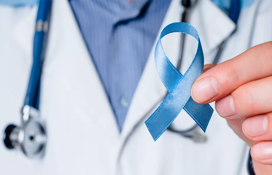 A healthcare provider holds the blue prostate cancer ribbon up, showing support.